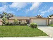 Charming single-story home with a well-manicured lawn and attached two-car garage at 625 Chilt Dr, Brandon, FL 33510