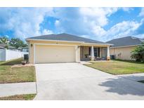 Charming one-story home featuring a two-car garage, well-maintained lawn, and a screened-in front porch at 727 Vineyard Reserve Ct, Seffner, FL 33584