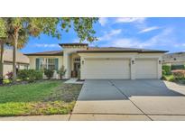 Charming one-story home with a three car garage and a well-manicured lawn with mature landscaping at 15706 Starling Water Dr, Lithia, FL 33547