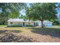 Charming single-story home with a metal roof, welcoming front porch and a manicured lawn at 4020 Mcintosh Rd, Dover, FL 33527