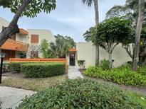 Inviting condo exterior with lush landscaping and a charming walkway to the front door at 135 Wild Palm Dr, Bradenton, FL 34210
