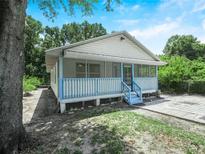 Charming cottage-style home featuring a screened front porch and blue trim at 3205 N 66Th St, Tampa, FL 33619