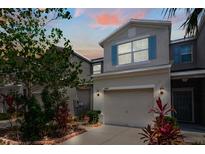 Charming townhome exterior with a two-car garage, neat landscaping, and neutral color palette at 10642 Lake Montauk Dr, Riverview, FL 33578