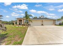 Inviting single-story home with a spacious three-car garage and well-manicured front yard at 11447 Adelia St, Spring Hill, FL 34608