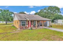 Charming one-story home with a covered front porch and a vibrant red front door at 3715 Fortner Rd, Plant City, FL 33567