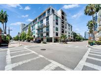 A modern, multi-story building with balconies and street views set against a blue sky with palm trees at 101 S 12Th St # 318, Tampa, FL 33602
