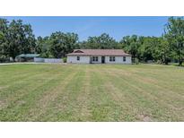 Charming single-story home featuring a bright, white exterior with a sprawling, green lawn at 7608 Franklin Rd, Plant City, FL 33565