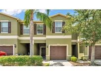 Charming townhome with a well-maintained exterior, lush landscaping, and a private garage at 2622 Lantern Hill Ave, Brandon, FL 33511