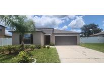 Well-manicured front exterior with lush lawn, mature landscaping and covered front entryway at 3188 Nubbin Ridge Ln, Zephyrhills, FL 33540