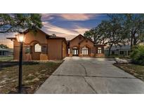 Charming home boasting an arched entryway, neutral stucco exterior, and spacious driveway at 5370 Boxtree Ct, Dade City, FL 33523