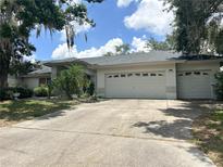 Charming single-story home with a spacious driveway and a two-car garage, complemented by lush landscaping at 1909 Masters Way, Plant City, FL 33566