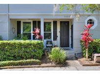 Charming front entrance with lush landscaping and a cozy seating area at 34852 Teeview Ln, Zephyrhills, FL 33541