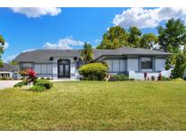 Charming single-story home with lush green lawn and landscaped garden beds, showcasing its curb appeal at 8721 Latham Ln, Hudson, FL 34667