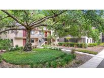 Inviting condo building featuring lush landscaping and an attractive stairwell to the upper units at 11704 Raintree Village Blvd # B, Temple Terrace, FL 33617