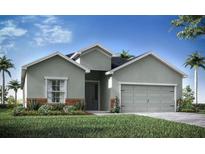 Charming single-story home featuring a gray exterior, landscaped yard, and a two-car garage at 35392 Coventry Fields Loop, Zephyrhills, FL 33541