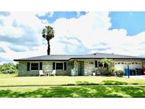 Charming single story home with a lush green lawn and a beautiful palm tree in the front yard at 704 Queens Ct, Seffner, FL 33584