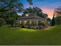Charming two-story home featuring a welcoming front porch and mature landscaping with a colorful sunset backdrop at 2802 Midway Rd, Plant City, FL 33565