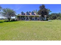 Spacious two-story home with a large front yard and covered porch, perfect for enjoying the outdoors at 4611 Executive Meadows Dr, Plant City, FL 33567