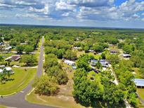 Expansive aerial view of a home nestled among lush greenery and trees, under a partly cloudy sky at 12410 Myrtlewood Dr, Riverview, FL 33579