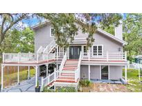 Charming two-story home with inviting double-door entry, staircase, and a spacious wrap around deck at 9934 Peninsular Dr, Gibsonton, FL 33534