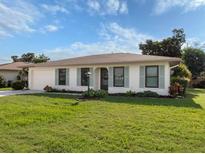 Ranch-style home with a green lawn and light-colored siding at 777 Vivienda South Ct # 6, Venice, FL 34293