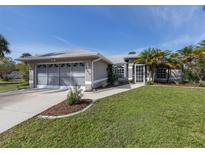 Single-story home with gray exterior, screened-in porch and attached garage at 3819 Ragen St, North Port, FL 34287