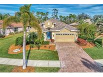 One-story house with tile roof, paver driveway, and lush landscaping at 5674 Blue Heron Cir, North Port, FL 34287