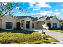 Single-story home with beige exterior and a large driveway at 11801 De Herreda Dr, North Port, FL 34287