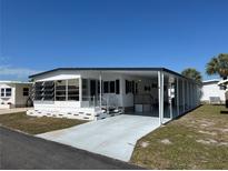 White single-wide mobile home with carport and landscaping at 213 Como Dr, Venice, FL 34285