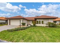 Single-story home with tile roof, attached garage, and landscaped lawn at 218 Laurel Hollow Dr # 10, Nokomis, FL 34275