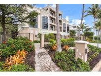 Elegant multi-story home with lush landscaping, featuring a paved walkway and a beautifully maintained garden at 361 Benjamin Franklin Dr # A, Sarasota, FL 34236