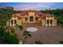 Luxury home with circular driveway, gated entrance, and lush landscaping at 2340 Bayshore Rd, Nokomis, FL 34275