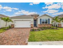 One-story home with brick paver driveway, two-car garage, and landscaped yard at 16090 Highgate St, Port Charlotte, FL 33953