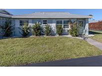 Light blue single story home with white shutters, landscaping, and walkway at 1015 Beach Manor Cir # 53, Venice, FL 34285