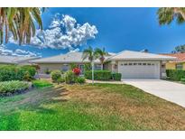 Single-story house with a white roof, attached garage, and lush landscaping at 1567 Waterford Dr, Venice, FL 34292