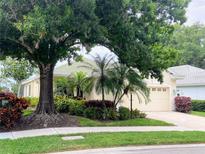 House exterior featuring a charming, light-yellow home with mature landscaping at 334 Melrose Ct, Venice, FL 34292