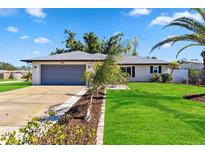 Updated single story home with gray garage door, mature landscaping, and a paved driveway at 268 Venice East Blvd, Venice, FL 34293