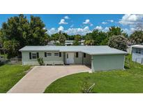 Single-story house with light green exterior, driveway, and yard at 2143 Starlite Ln, Port Charlotte, FL 33952