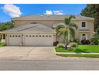 Tan two-story house with three-car garage and palm tree at 8188 Shadow Pine Way, Sarasota, FL 34238