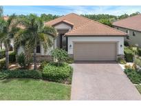 Beautiful one-story home with a two-car garage and lush landscaping at 10079 Crooked Creek Dr, Venice, FL 34293