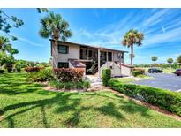 Two-story condo building with palm trees at 925 Capri Isles Blvd # 1, Venice, FL 34292