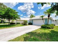 Light blue house with a white garage door and landscaped yard at 803 Harrington Lake N Dr # 75, Venice, FL 34293