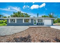 Gray house with white trim, deck, and landscaping at 4090 Pelican Shores Cir, Englewood, FL 34223