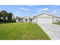 Newly constructed home with a spacious lawn and a two-car garage at 2676 Cover Ln, North Port, FL 34286