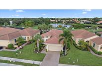 Aerial view of a single-Gathering home with a tile roof in a golf course community at 162 Palazzo Ct, North Venice, FL 34275