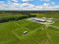 Aerial view of expansive equestrian property with multiple barns and paddocks at 27000 Harrison Rd, Sidell, FL 34266