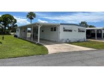 White mobile home with carport and landscaping at 200 Roma Rd, Venice, FL 34285