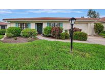 Charming ranch home with a well-manicured lawn and walkway at 5103 Greencroft Rd # 24, Sarasota, FL 34235