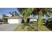 One-story home with a white garage door and palm trees at 5295 Drew Rd, Venice, FL 34293