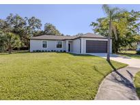 Newly built home with a modern exterior, attractive landscaping, and a two-car garage at 3588 Erie Ct, North Port, FL 34287